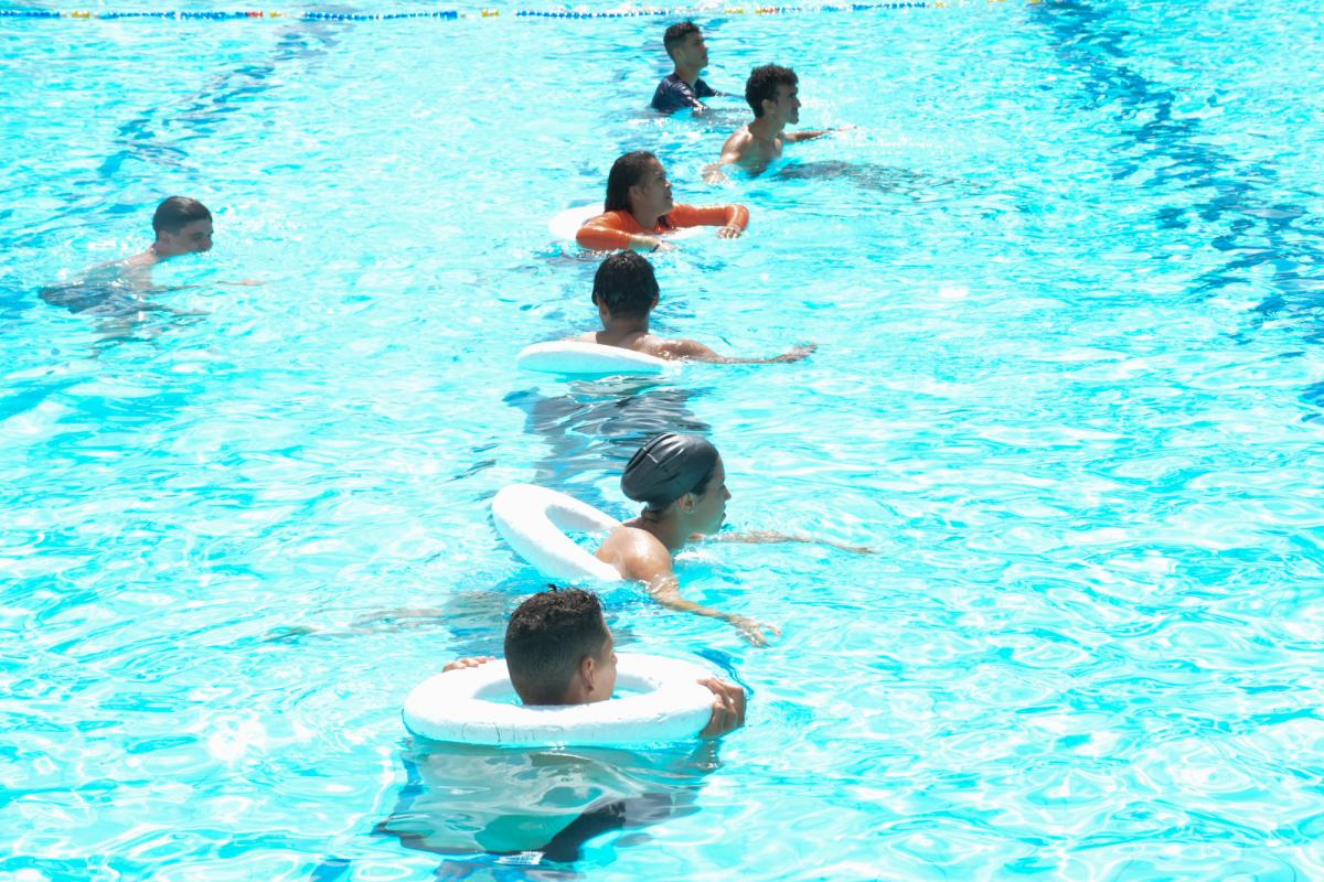estudantes com boias na piscina 