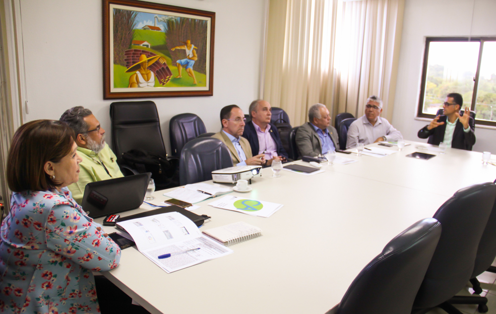 Fotos dos reitores e participantes do encontro discutindo, numa mesa de reuniões