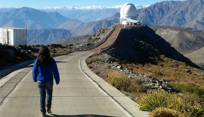 imagem da aluna Inês de costas caminhando rumo ao telescópio Soar no Chile