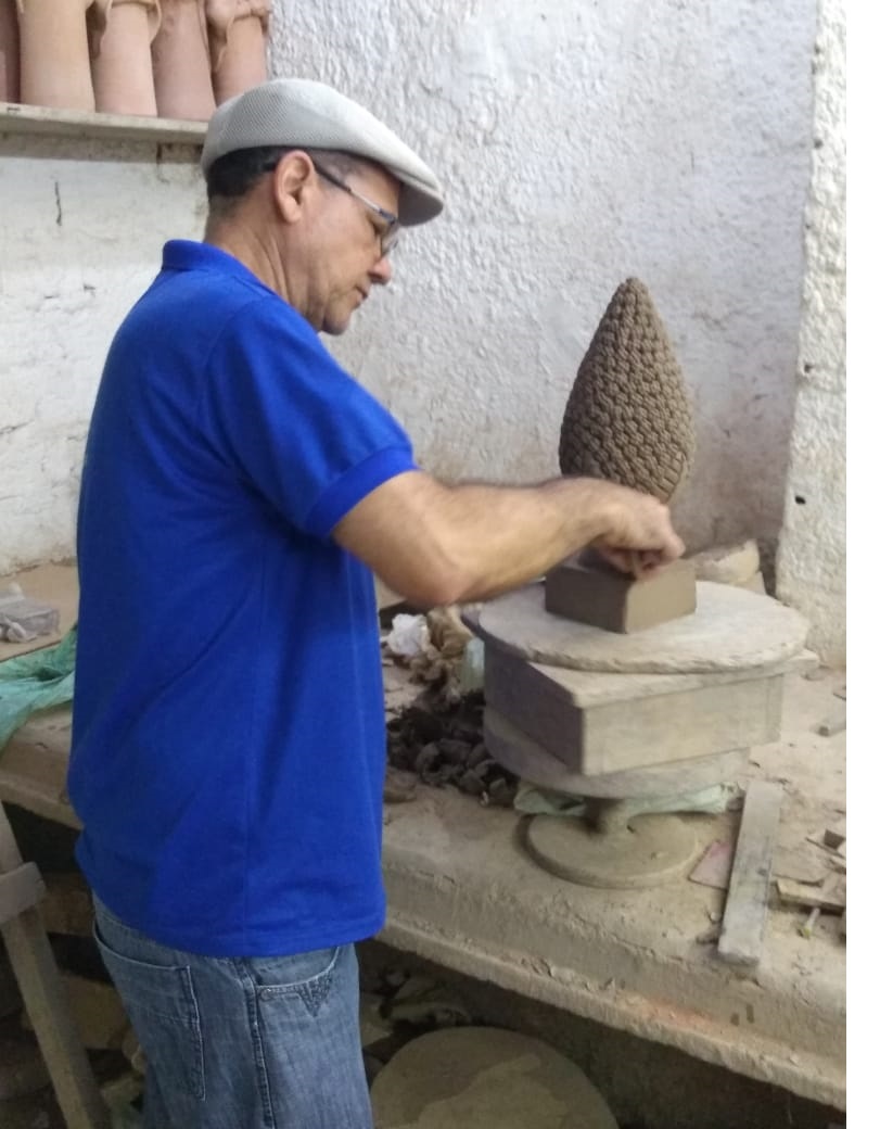 carlos zezinho mexendo no barro para criar obra